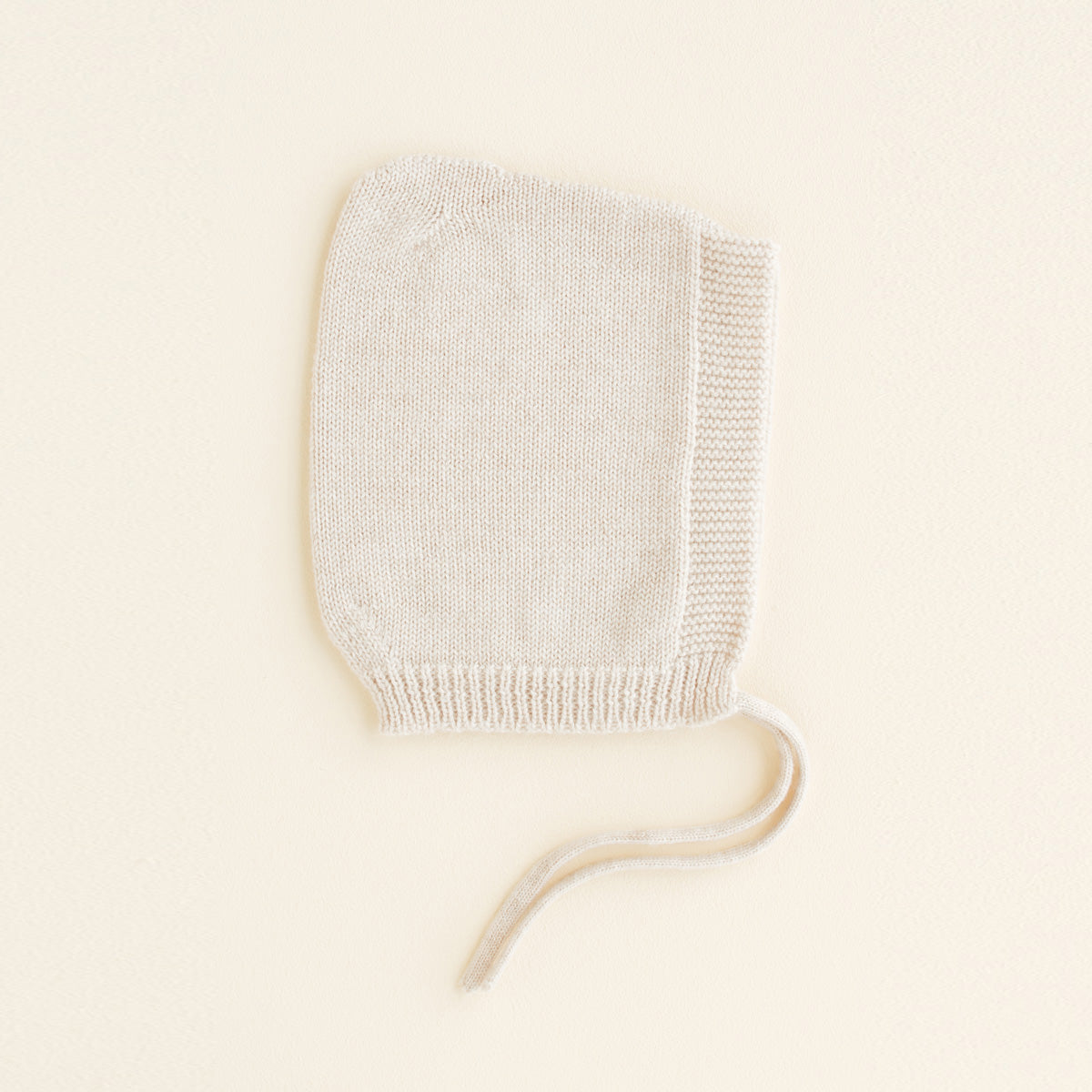 HVID seamlessly knitted baby bonnet in extra fine Italian merino wool with a cute peak detail in cream