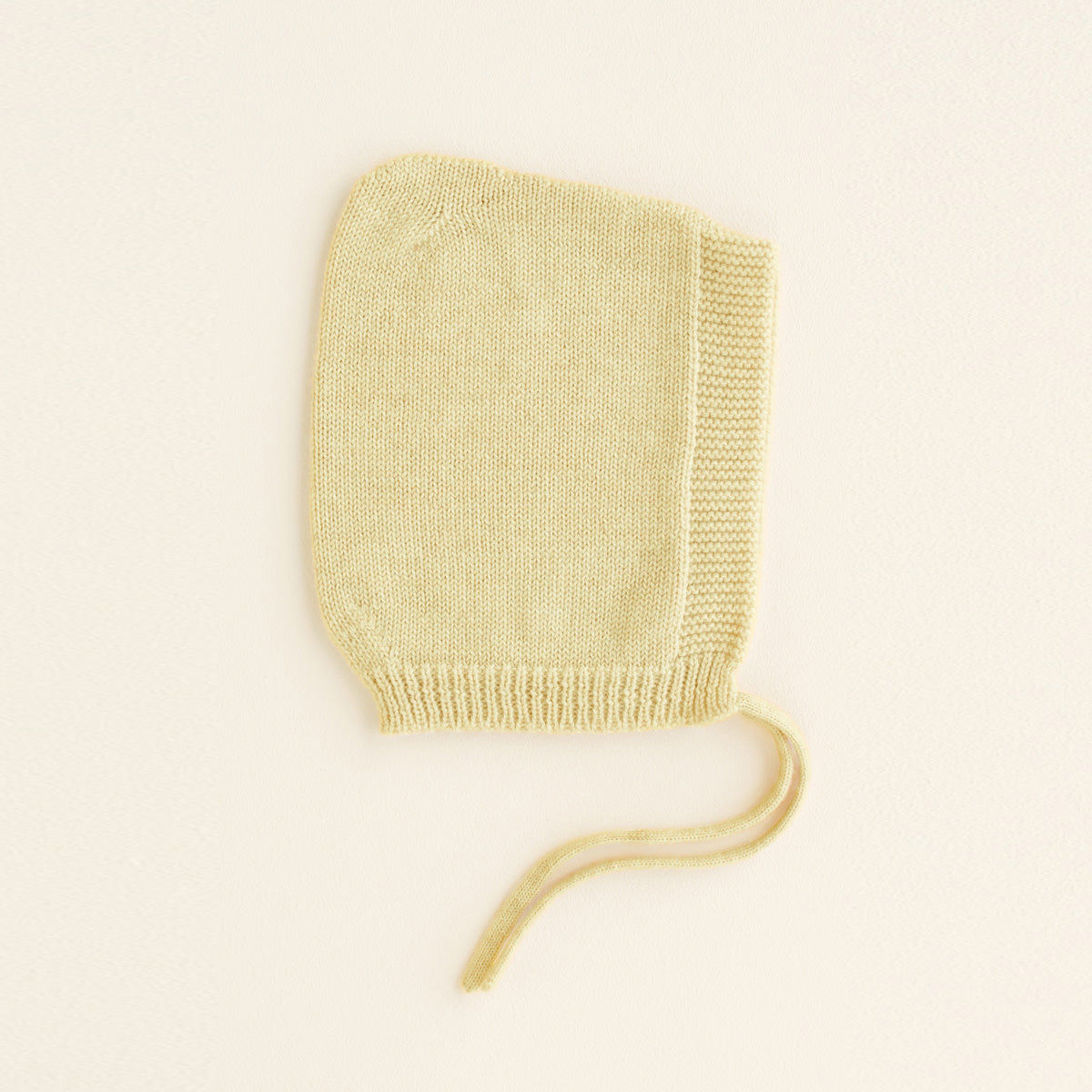 HVID seamlessly knitted baby bonnet in extra fine Italian merino wool with a cute peak detail in light yellow