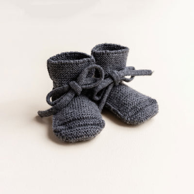 Soft Hvid baby booties in charcoal, knitted from 100% merino wool in Belgium – warm and breathable booties that stay on tiny feet.