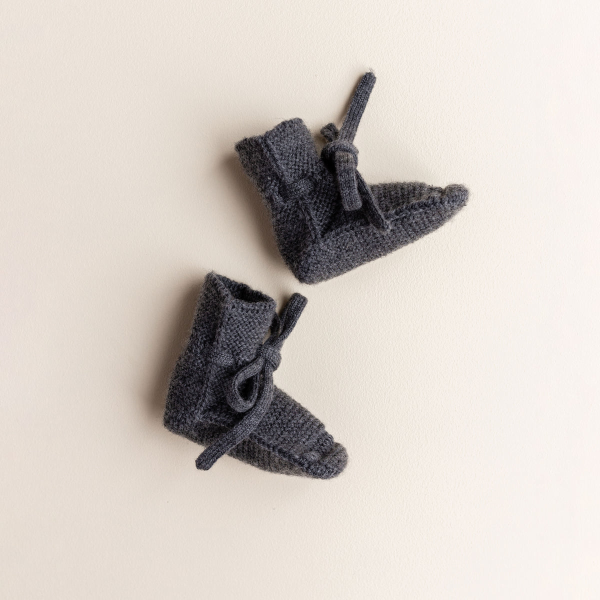 Soft Hvid baby booties in charcoal, knitted from 100% merino wool in Belgium – warm and breathable booties that stay on tiny feet.