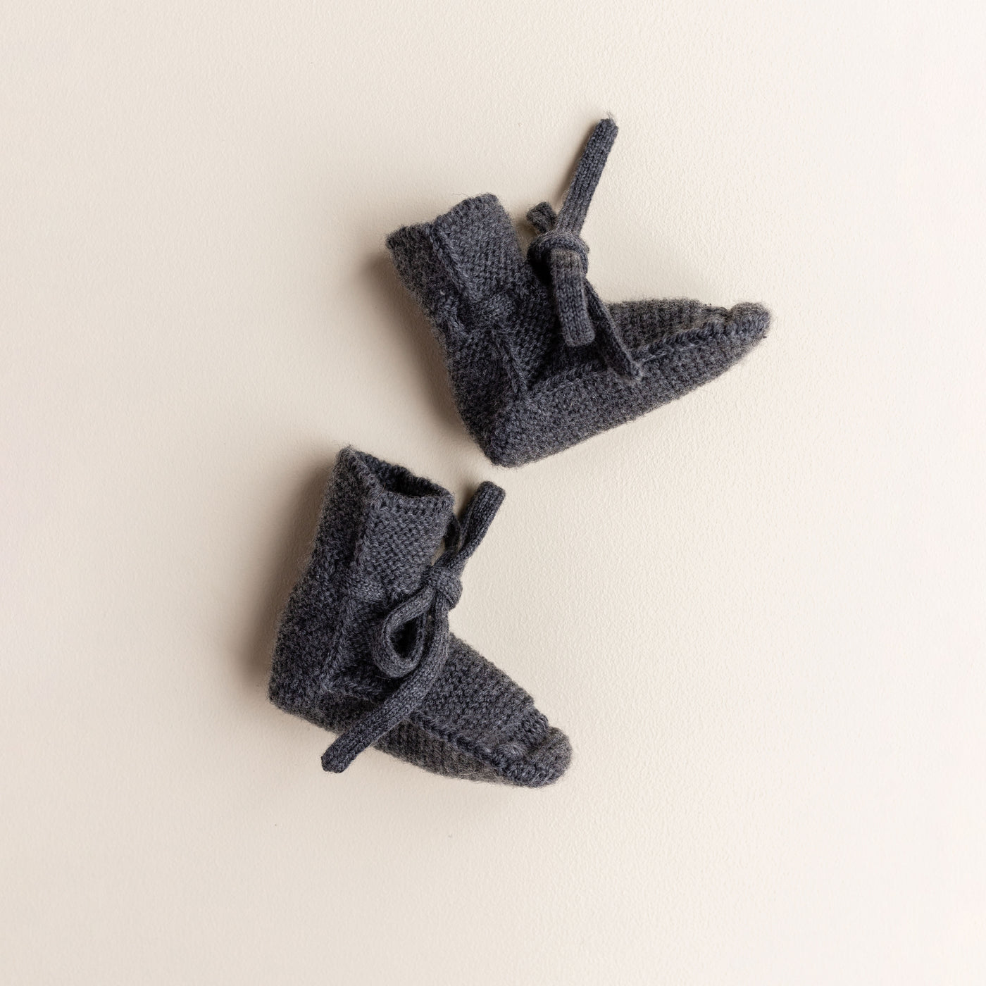Soft Hvid baby booties in charcoal, knitted from 100% merino wool in Belgium – warm and breathable booties that stay on tiny feet.