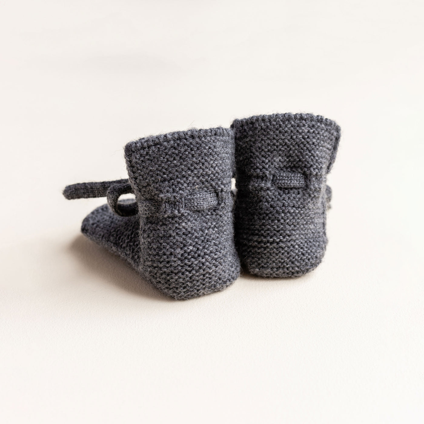 Soft Hvid baby booties in charcoal, knitted from 100% merino wool in Belgium – warm and breathable booties that stay on tiny feet.