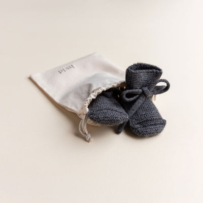 Soft Hvid baby booties in charcoal, knitted from 100% merino wool in Belgium – warm and breathable booties that stay on tiny feet.