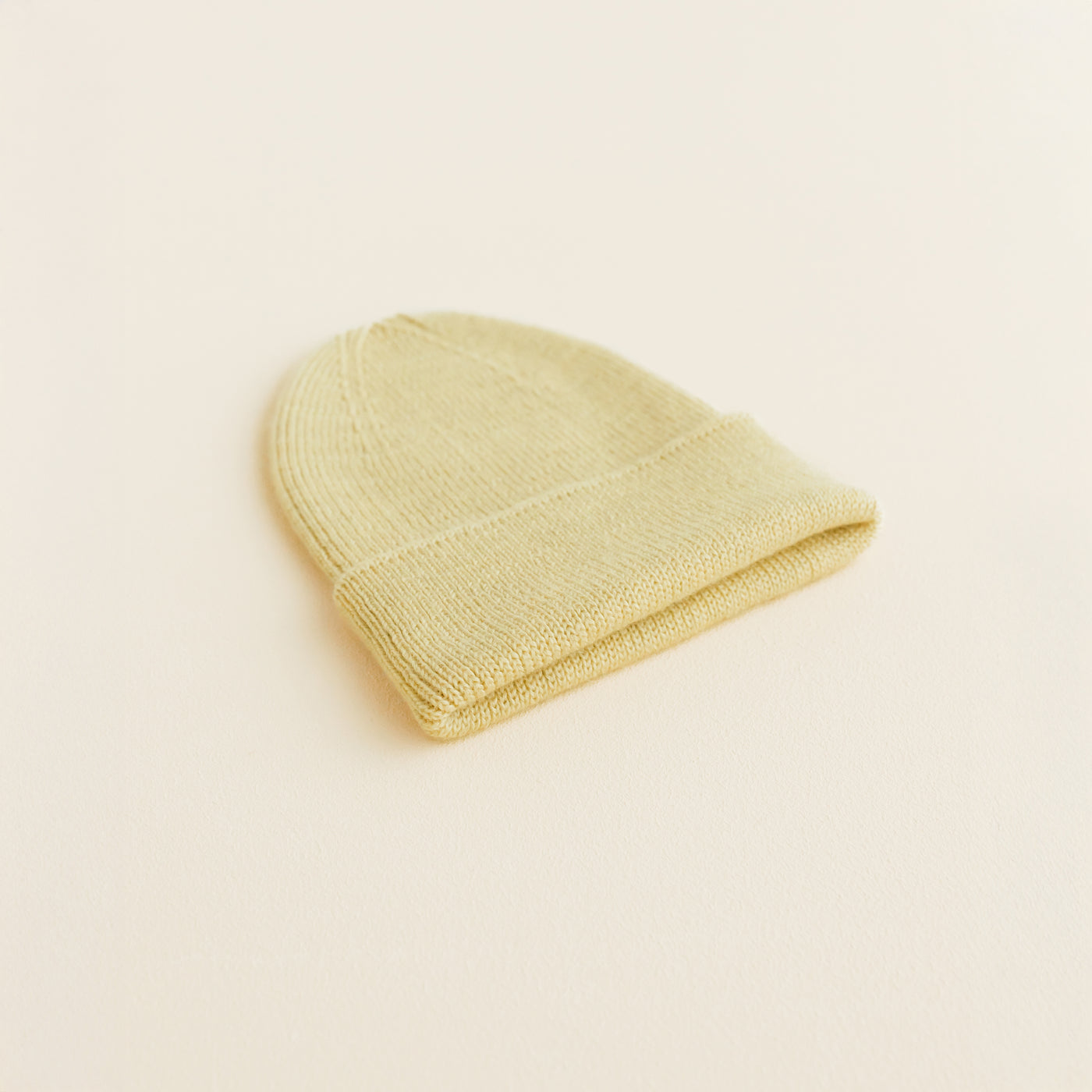 Hvid Beanie Fonzie in Newborn Light Yellow – soft ribbed merino wool baby beanie, knitted in Belgium for warmth, comfort, and a perfect newborn fit.