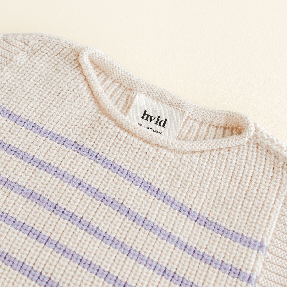 Hvid Vest Harvey in cream lila stripe, a seamless baby vest made from extra fine merino wool with a soft fisherman’s rib and elastic neckline, knitted in Belgium.