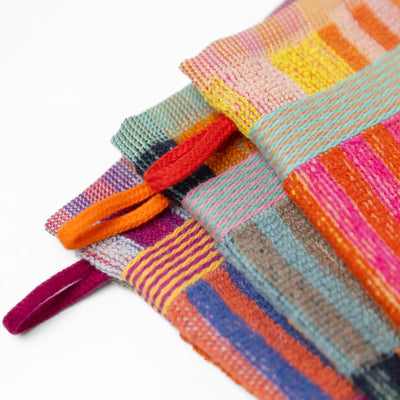 3 pack wash cloths by Foekje Fleur. Colorful cotton textile made from leftover yarns, featuring unique woven color combinations and a hanging label, photographed folded on a neutral background.