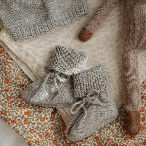 Hand-knitted baby booties made of pure baby alpaca wool by Main Sauvage, hypoallergenic, thermoregulating, and eco-friendly.
