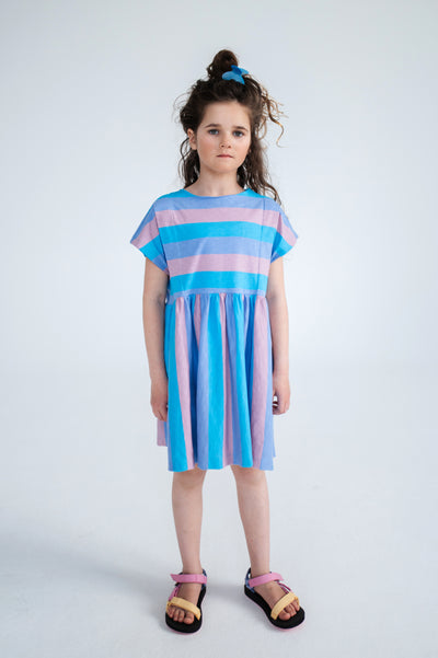 Tricolor block stripe dress made from 100% yarn-dyed organic cotton flamé. Features pleated front details, ruffled waist, side pockets, short sleeves, and raw edge neckline. A lightweight and comfortable dress for everyday wear