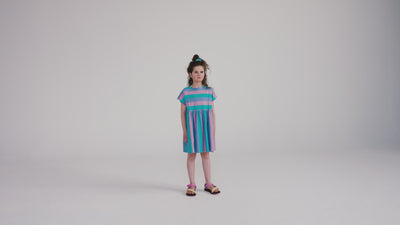 Tricolor block stripe dress made from 100% yarn-dyed organic cotton flamé. Features pleated front details, ruffled waist, side pockets, short sleeves, and raw edge neckline. A lightweight and comfortable dress for everyday wear.